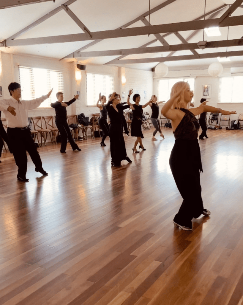 A ballroom dance instructor teaching a class.