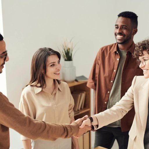 Two people shaking hands in a business office.