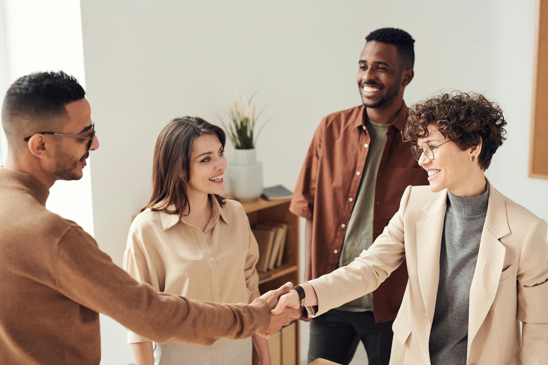 Two people shaking hands in a business office.